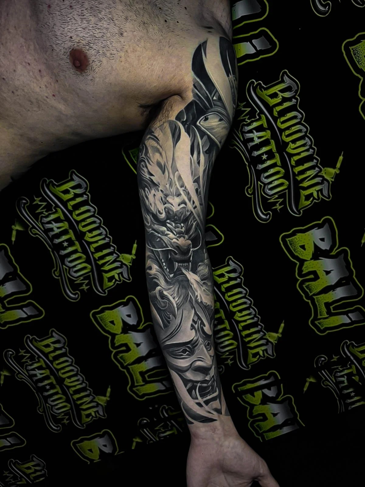 Healed black-and-grey sleeve with a dragon, Hannya mask, and watchful eye, showing smooth gradients and crisp healed line integrity at Bloodline Tattoo Bali.